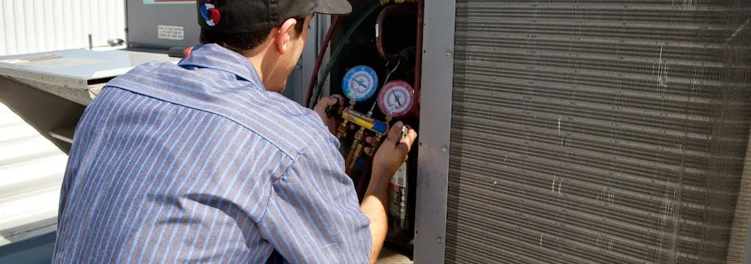 HVAC technician servicing a condenser unit in Perryton